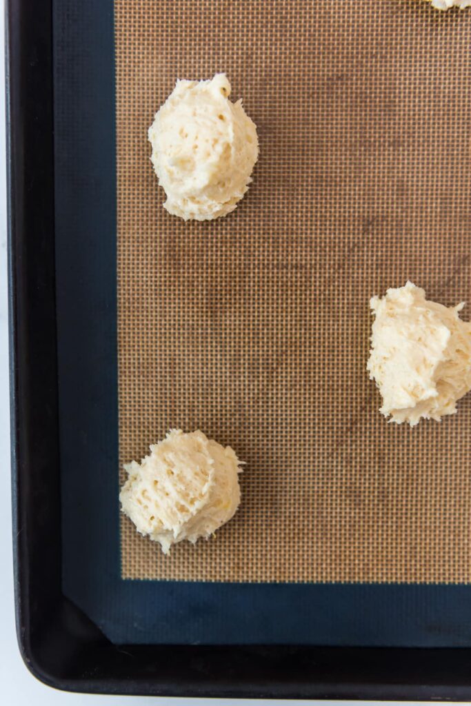 scoops of cookie batter on baking sheet with silpat mat