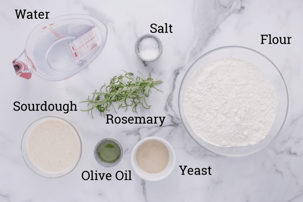 ingredients for sourdough discard focaccia on marble counter with text overlay