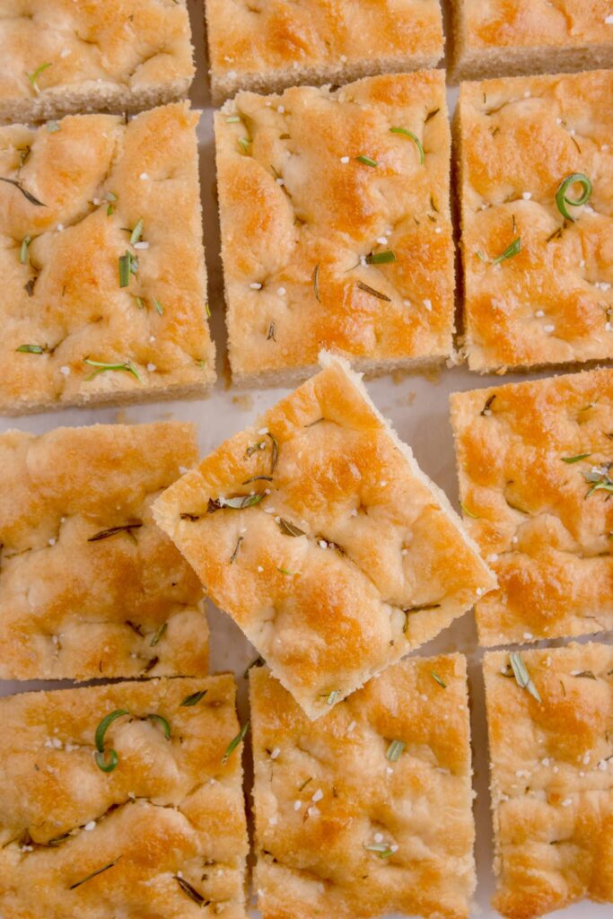 squares of focaccia lined up with one pulled out and angled on top