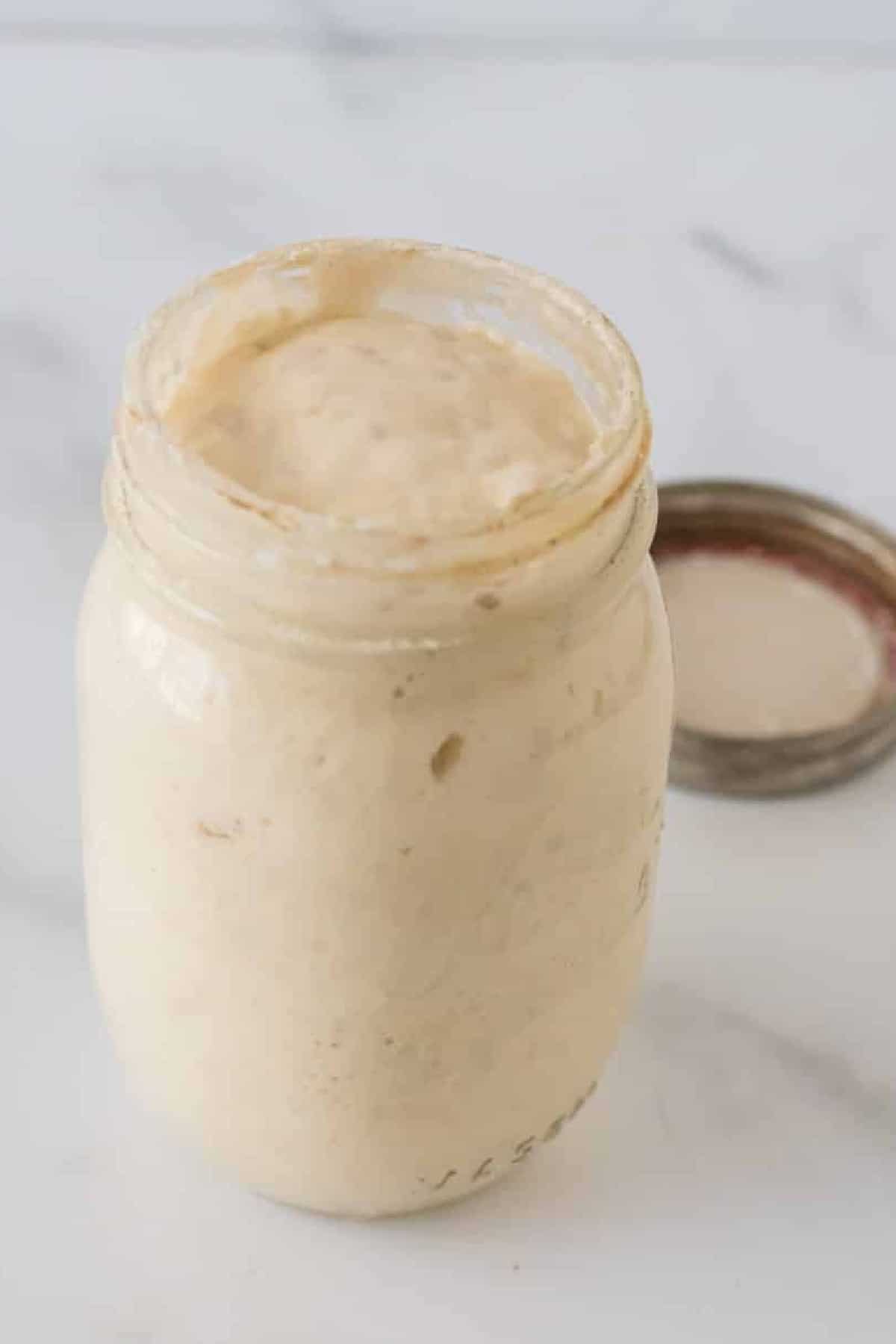 glass mason jar filled with active sourdough starter