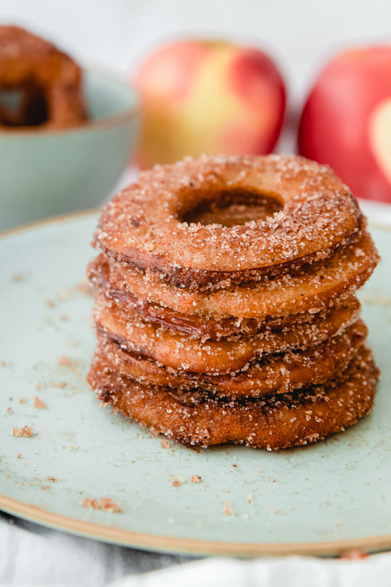 stack of fried batter dipped apple slices coated in cinnamon sugar