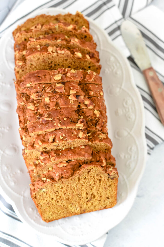 sourdough pumpkin bread loaf cut into slices and layered on white tray