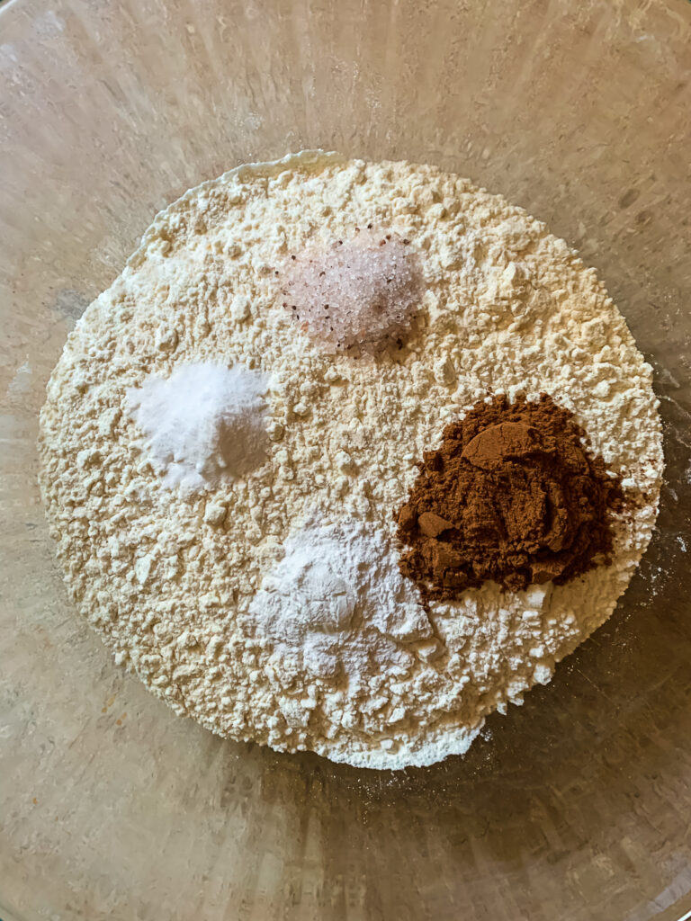 glass bowl filled with flour an spices and other dry ingredients