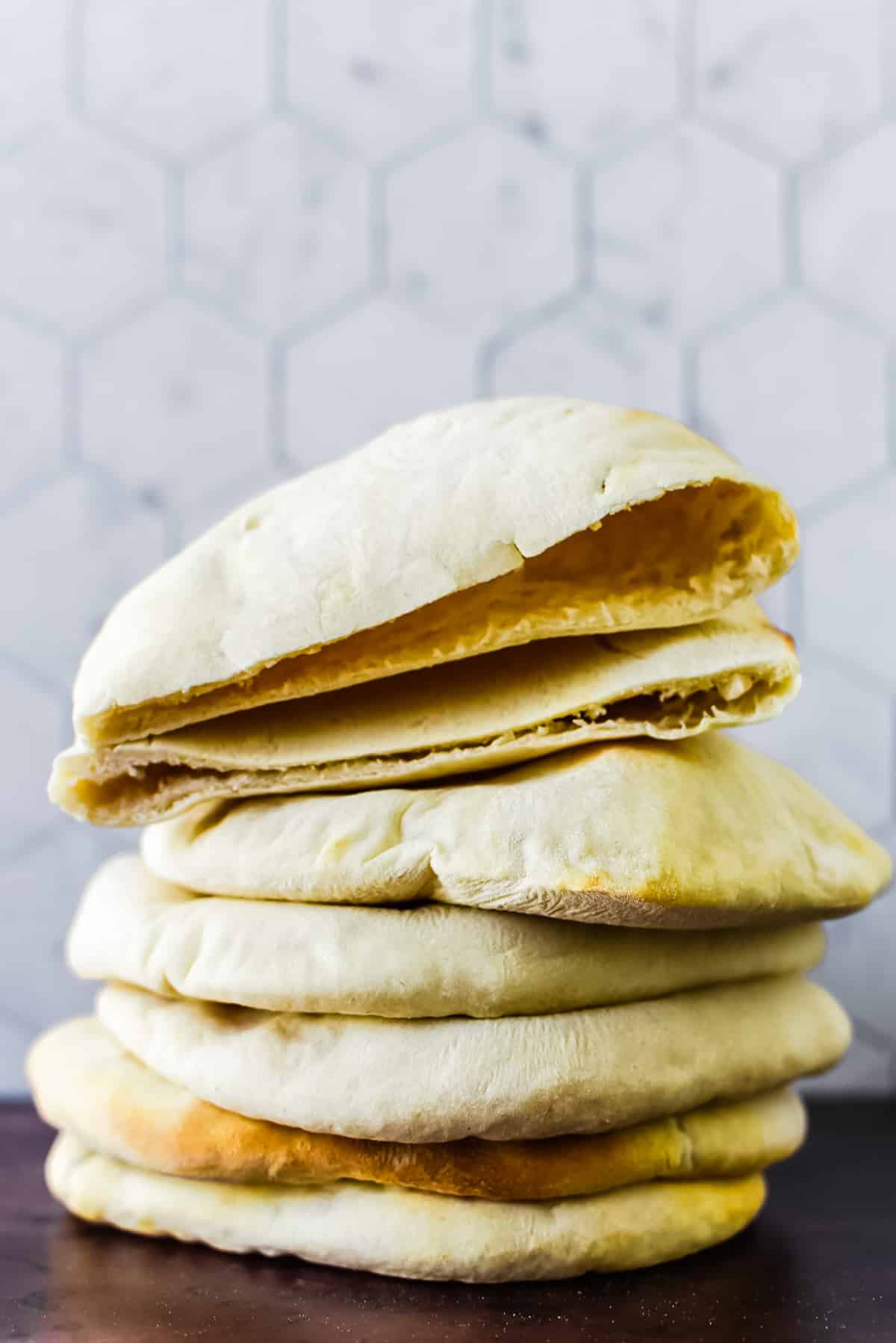 stack of five sourodugh pita with top pita cut in half to show inside