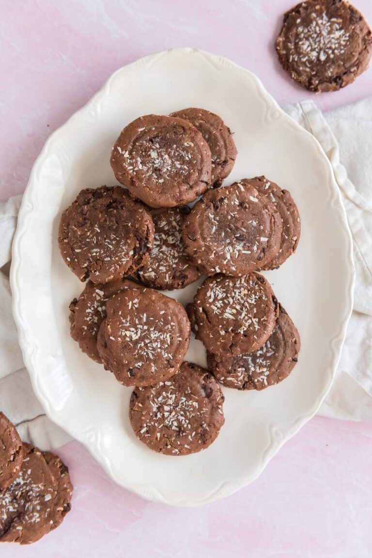 white platter filled with chocolate cookies sprinkled with coconut
