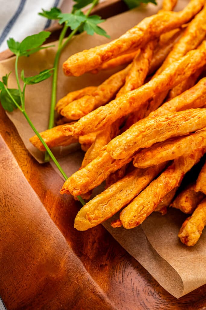 sourdough cheese straws piled on parchment paper
