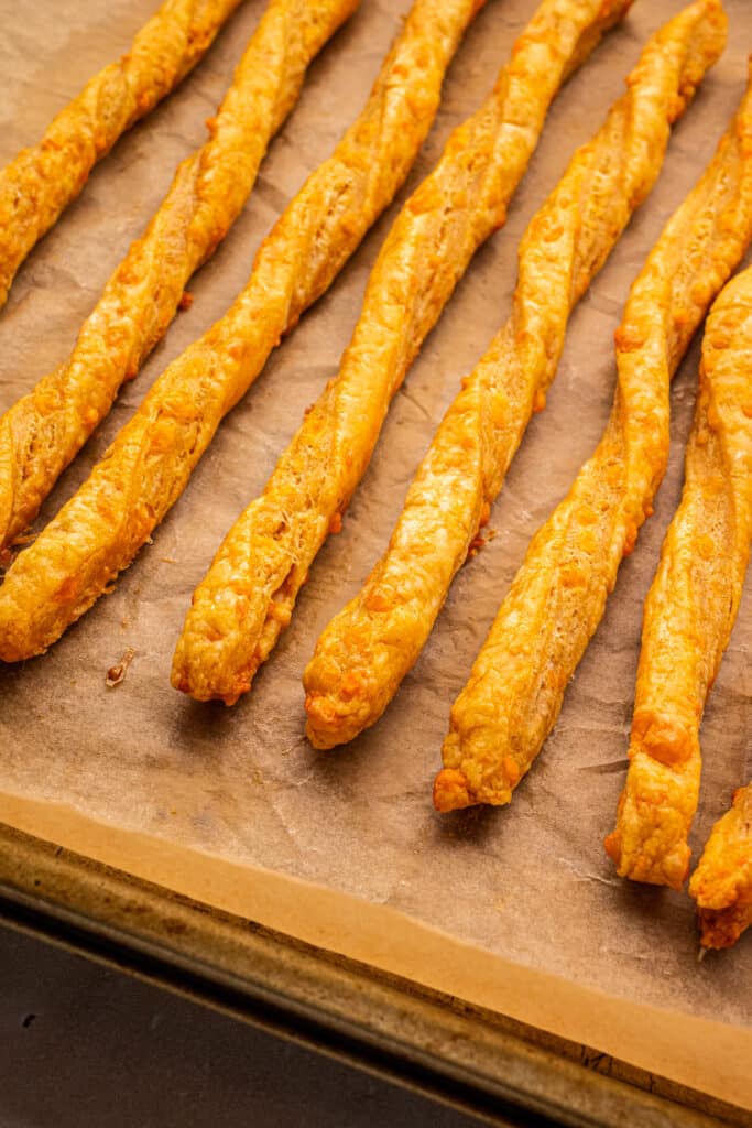 freshly baked cheese straws on baking tray