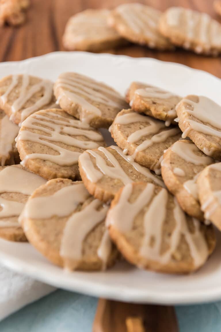 sourdough maple walnut cookies with maple drizzle on white platter