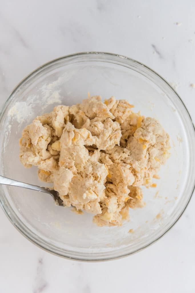 glass mixing bowl with batter for cheddar drop biscuits with discard