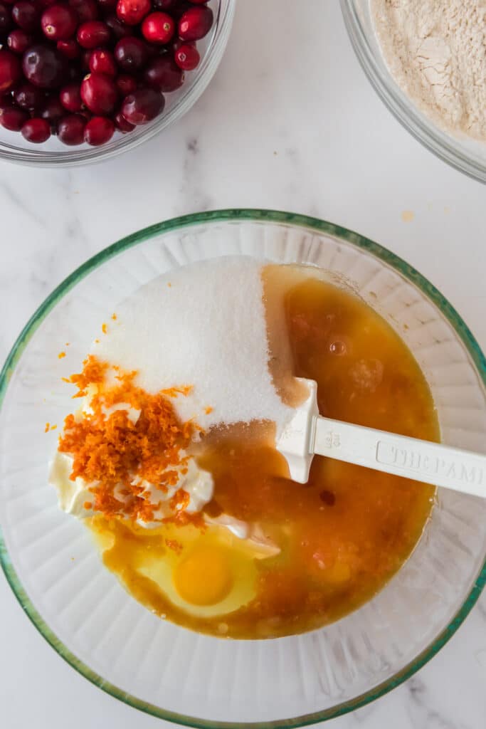 overhead of bowl with wet ingredients of muffins mixed with white silicone spatula