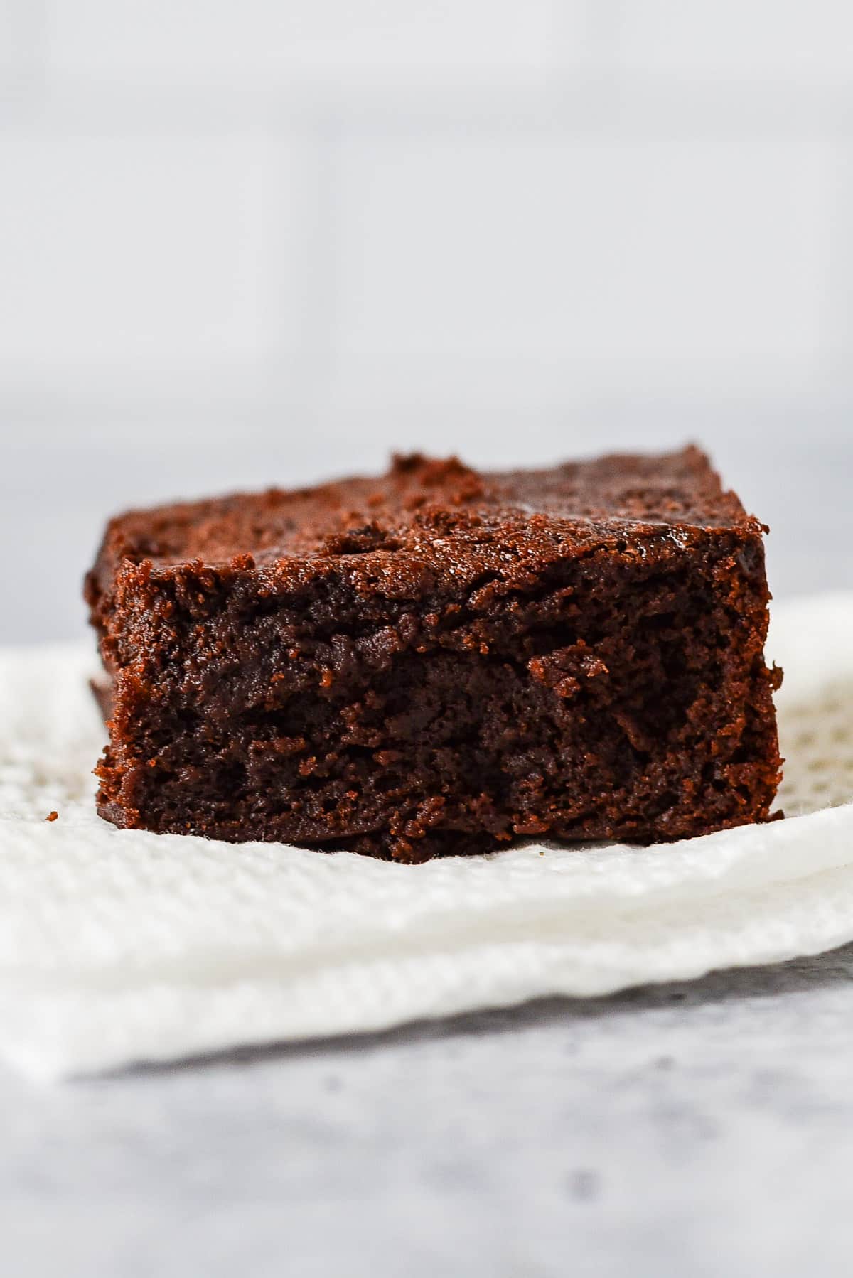 closeup of one sourdough brownie on paper towel
