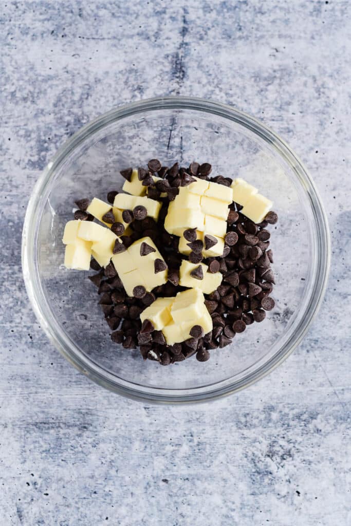 glass mixing bowl with cubes of butter and chocolate chips