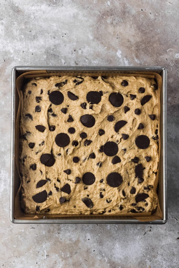 metal baking pan with sourdough cookie dough and chocolate on top