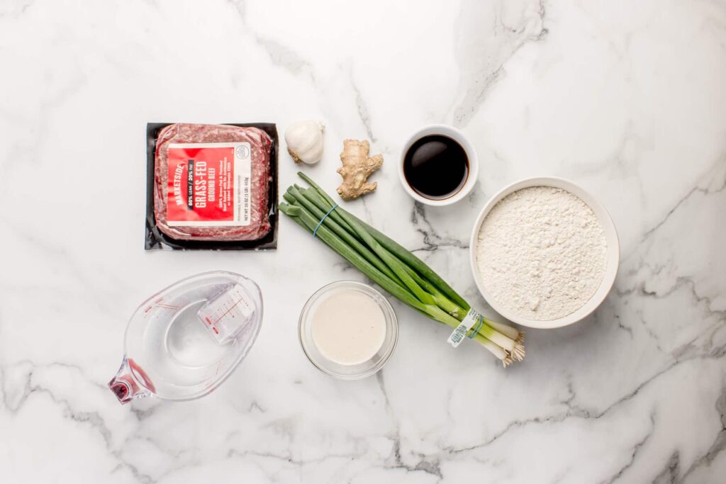 ingredients for beef dumplings with discard wrappers on marble counter