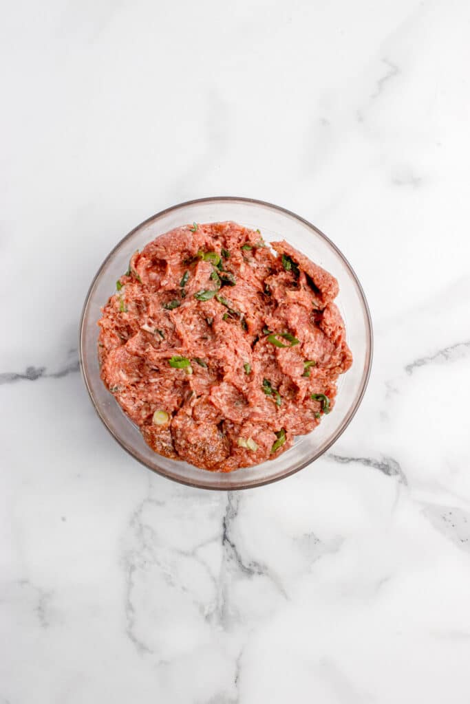 glass mixing bowl with mixed ginger beef dumpling filling