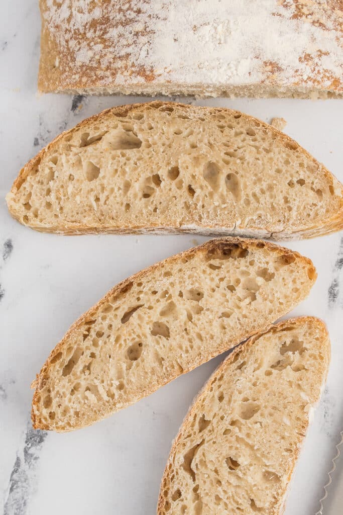 three slices of sourdough ciabatta arranged on marble counter