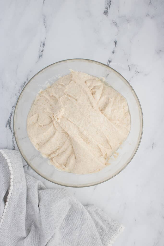 glass bowl with sourdough ciabatta dough after one round of stretch and folds