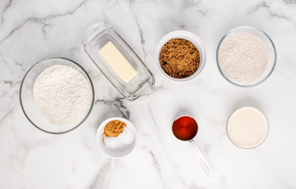 ingredients for sourdough graham crackers on marble counter  in glass bowls