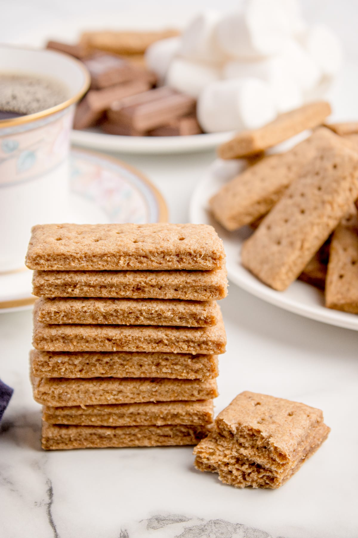 stack of graham crackers made with sourdough stacked together with bowl behind it