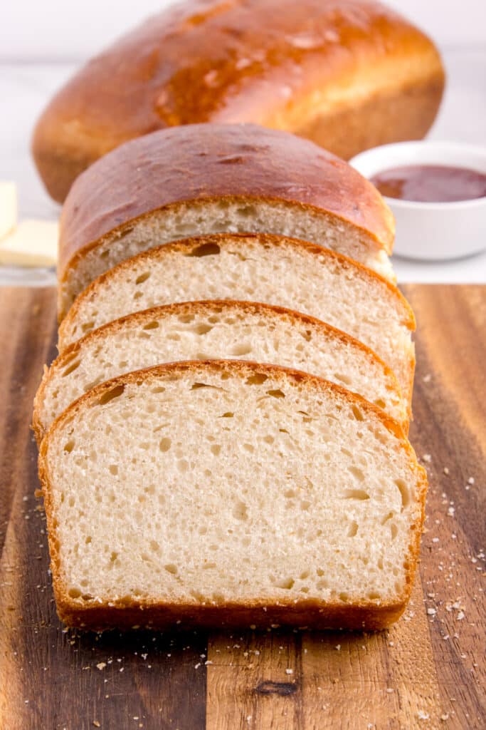 sourdough potato flake bread sliced and stacked together with loaf in background