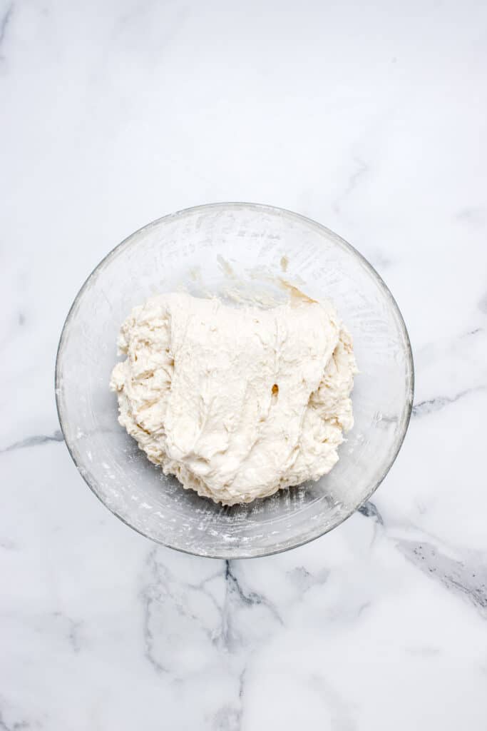sourdough bread dough in glass bowl getting stretch and fold