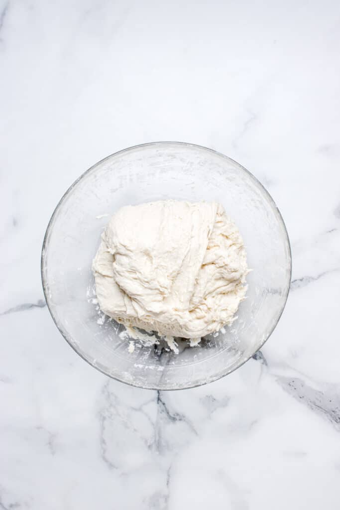 sourdough bread dough in glass bowl getting stretch and fold