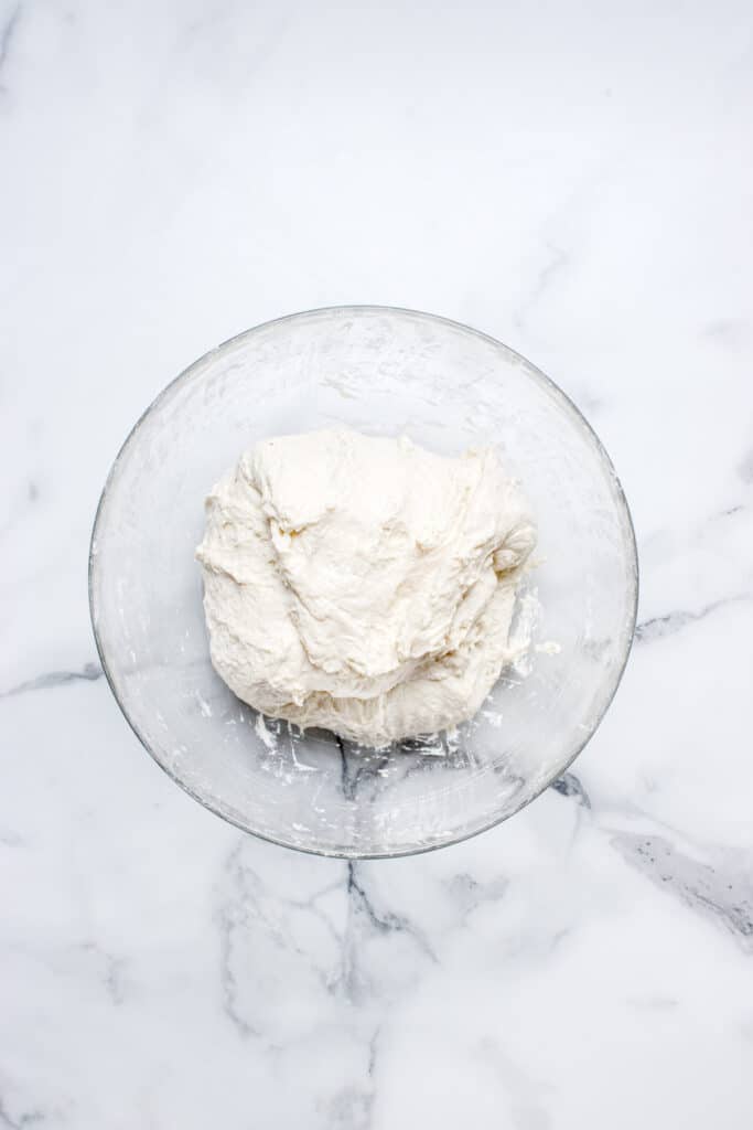 sourdough bread dough in glass bowl getting stretch and fold