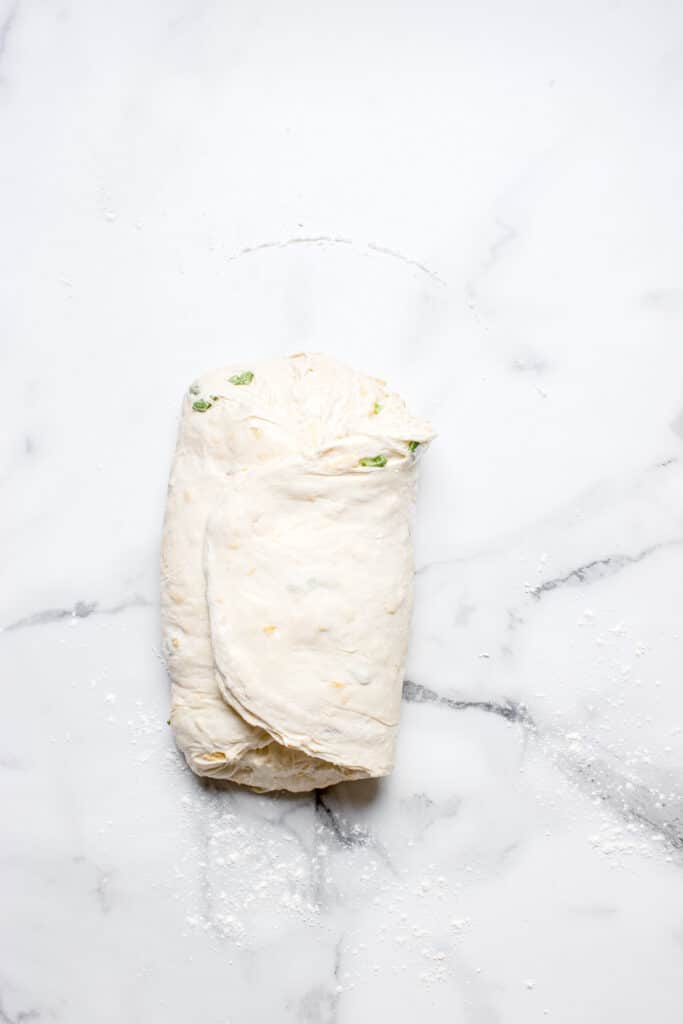 sourdough bread dough with sides tucked in to shape dough