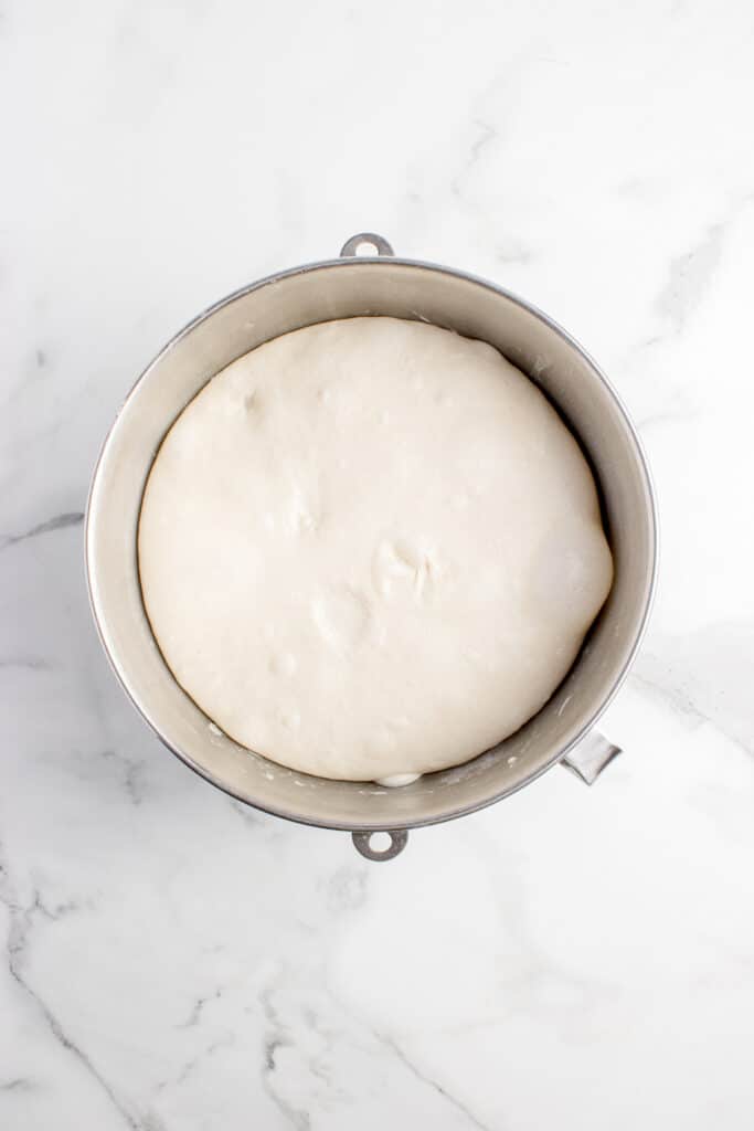 metal mixing bowl with dough that has doubled