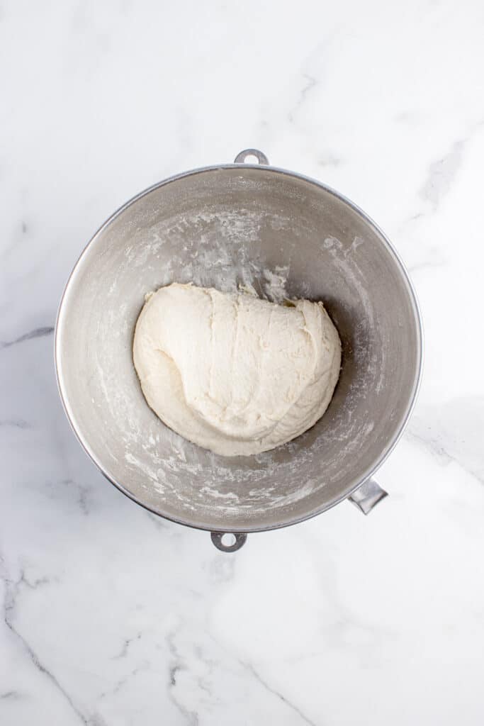 metal mixing bowl with focaccia dough getting a stretch and fold