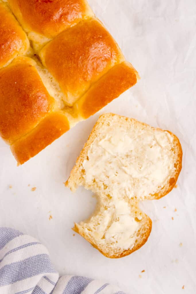 sourdough brioche loaf with one slice cut and buttered and bite taken out of it