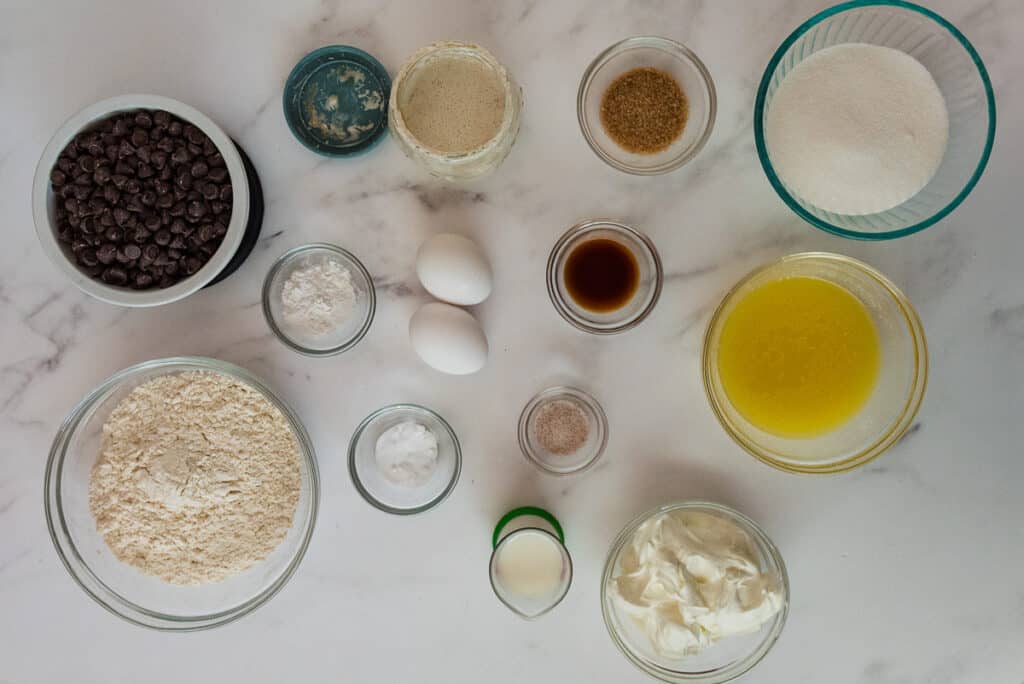 overhead view of ingredients for discard chocolate chip muffins in glass bowls on counter