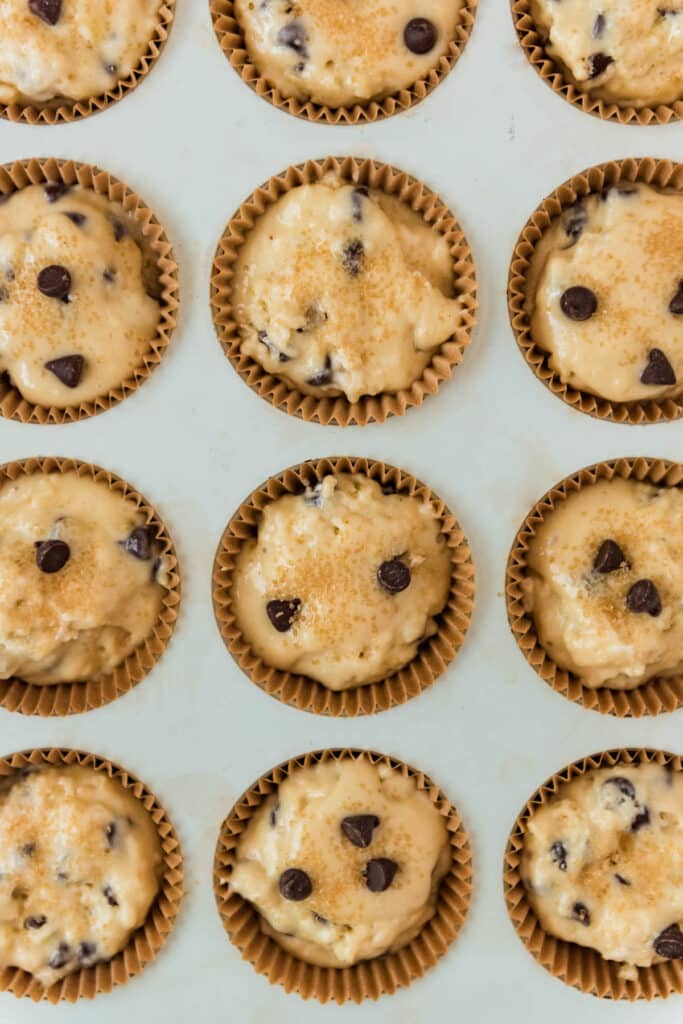 closeup of muffin batter in muffin pan with turbinado sugar on top