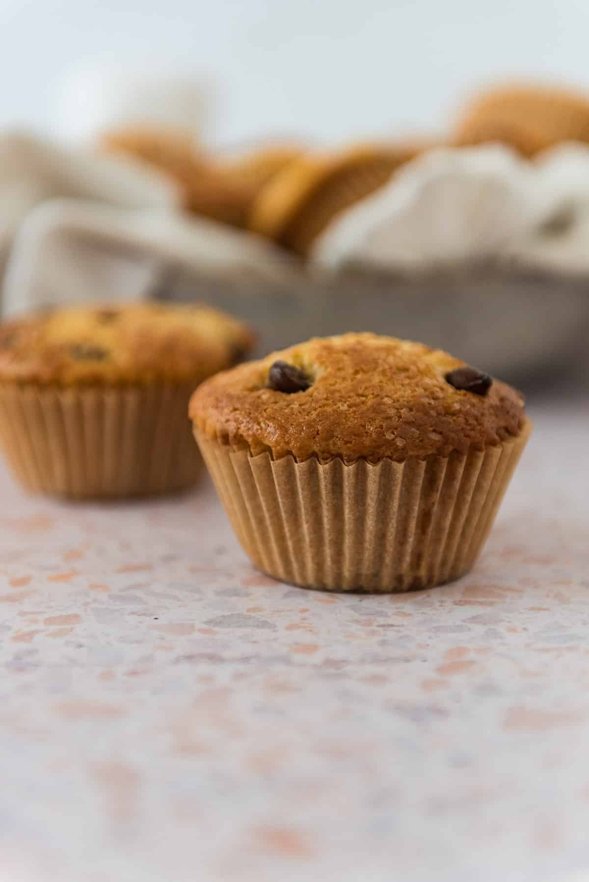 sourdough discard chocolate chip muffins on counter with bowl in background