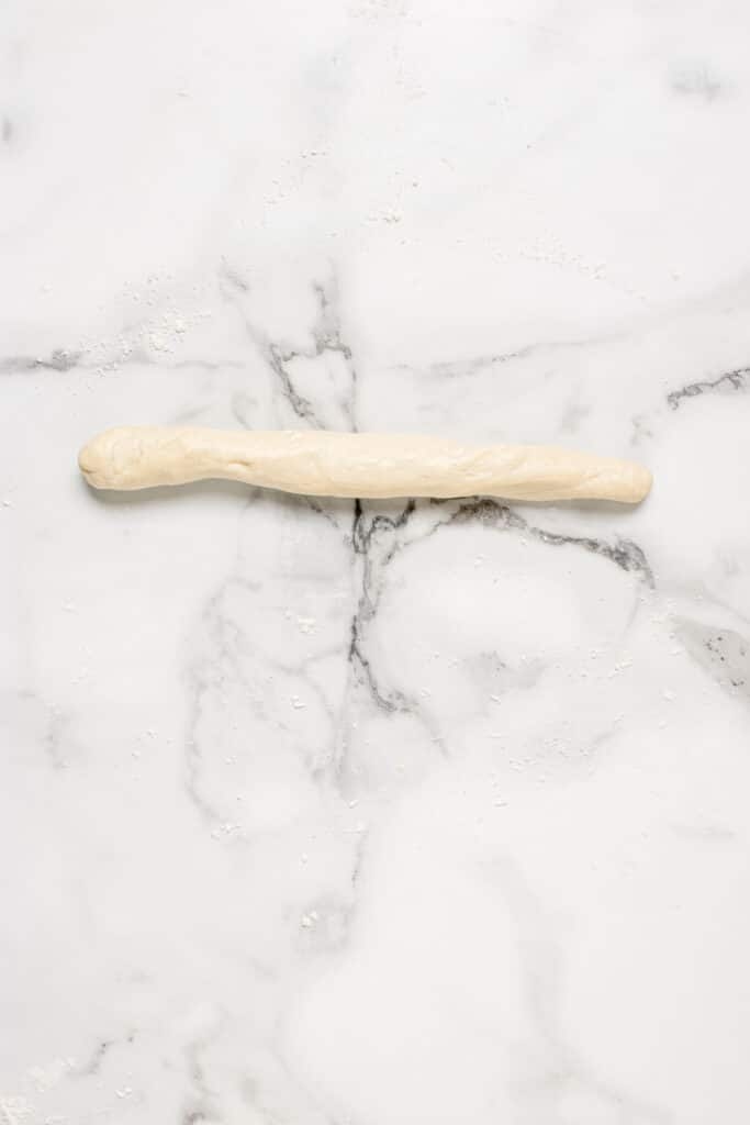 a piece of sourdough dough rolled into a log