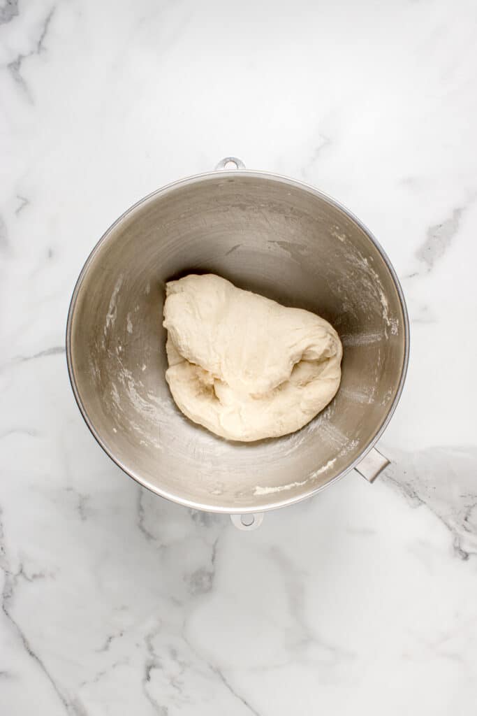 metal mixing bowl with dough for garlic knots after stretch and fold