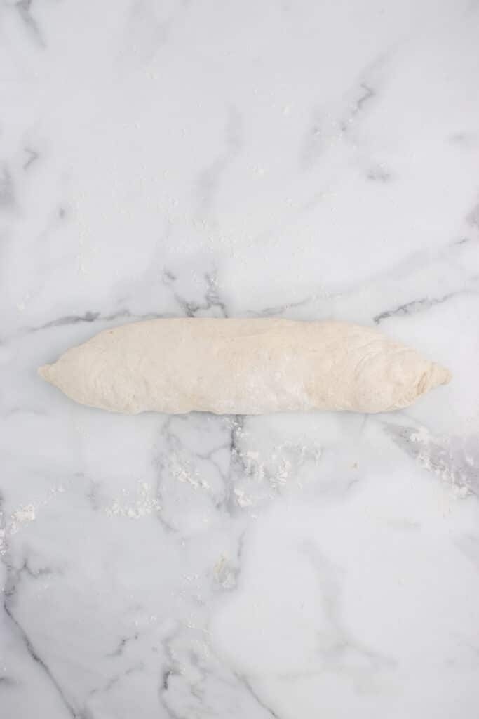 log of dough rolled and edges pinched