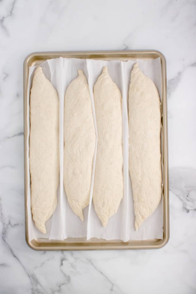 four sourdough baguette  on baking pan