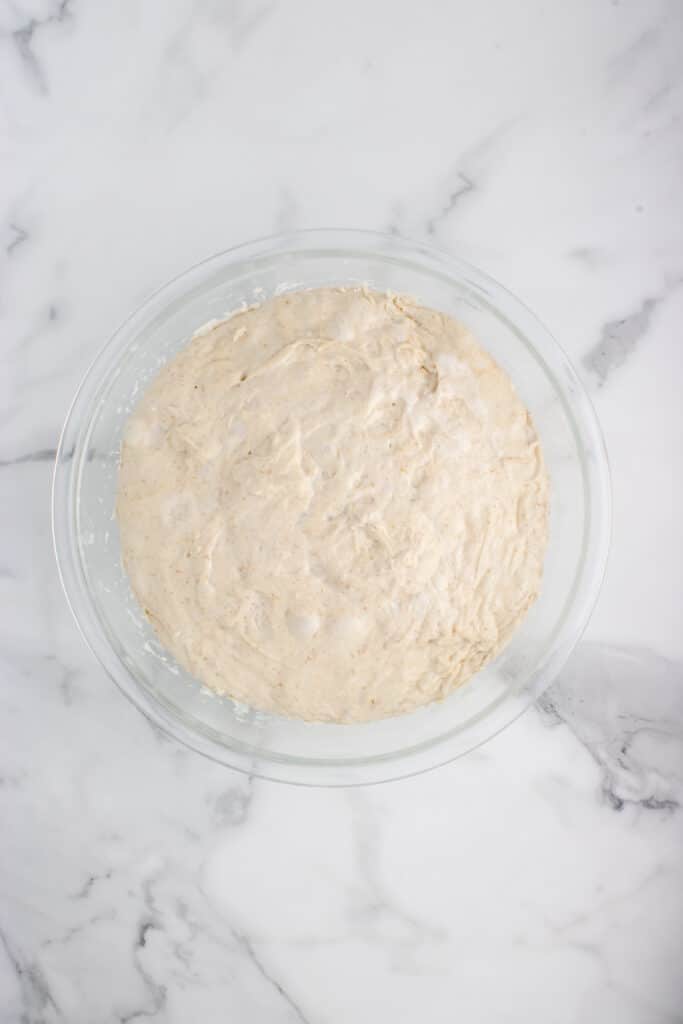 glass mixing bowl of dough after bulk fermentation
