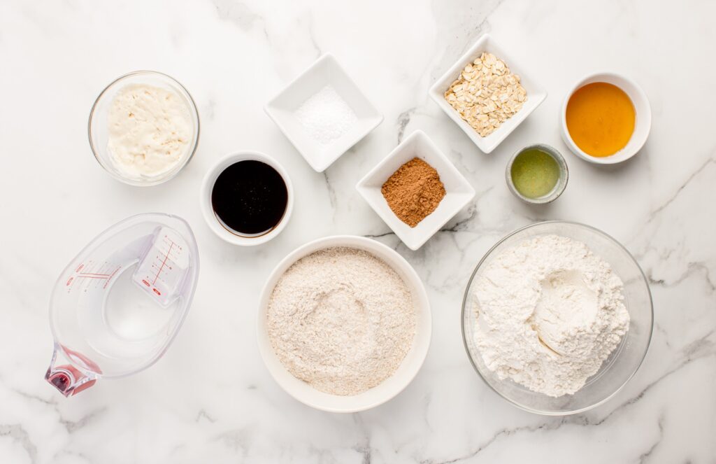 overhead view of ingredients for sourdough brown bread on marble counter