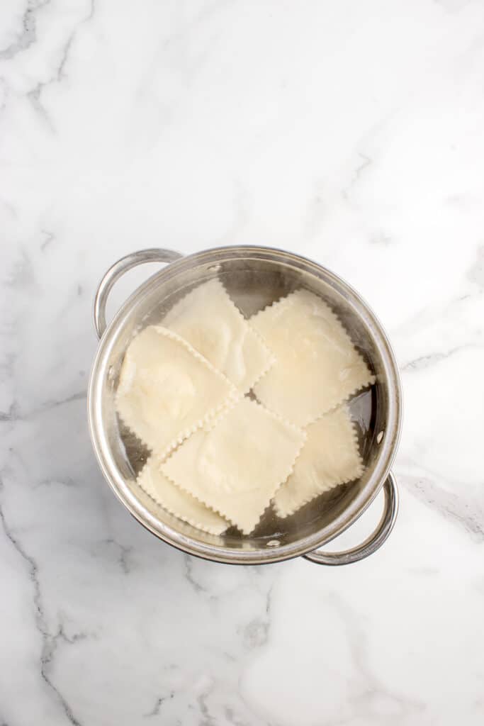large saucepan with boiling water and sourdough cheese ravioli cooking