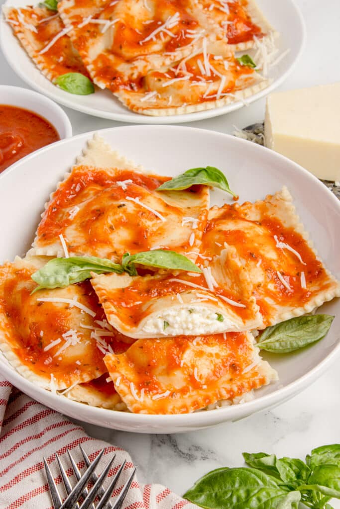 two plates with sourdough cheese ravioli  with one ravioli cut in half to show cheese filling