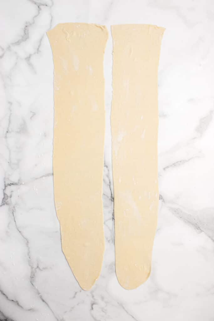 two pieces of ravioli dough rolled out into strips