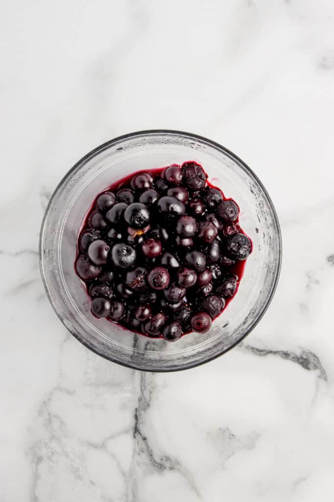 glass bowl with blueberries on marble counter