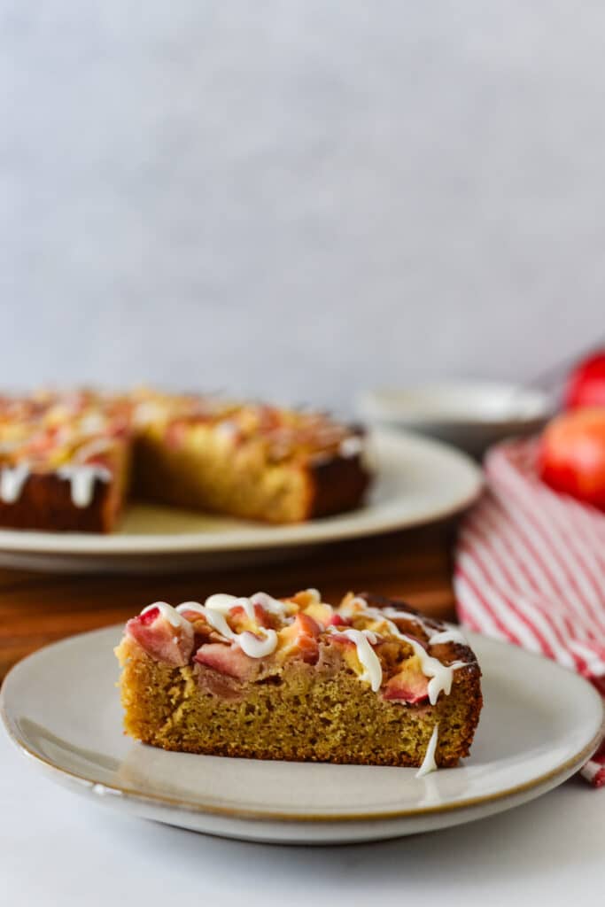 slice of sourdough apple cake on grey plate with rest of platter in background