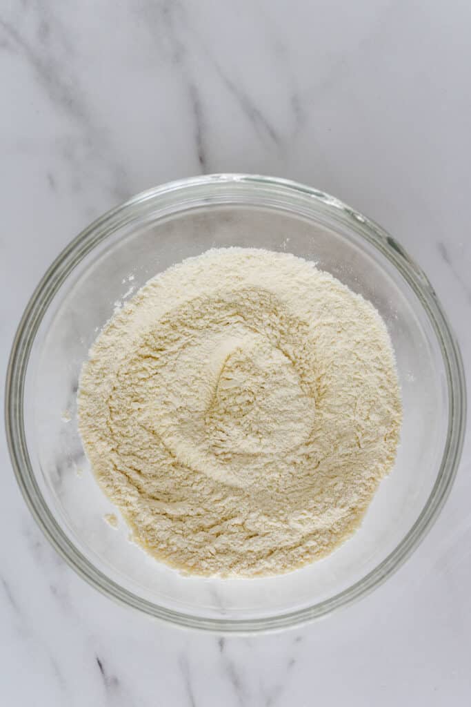 glass mixing bowl with whisked dry ingredients for apple cake