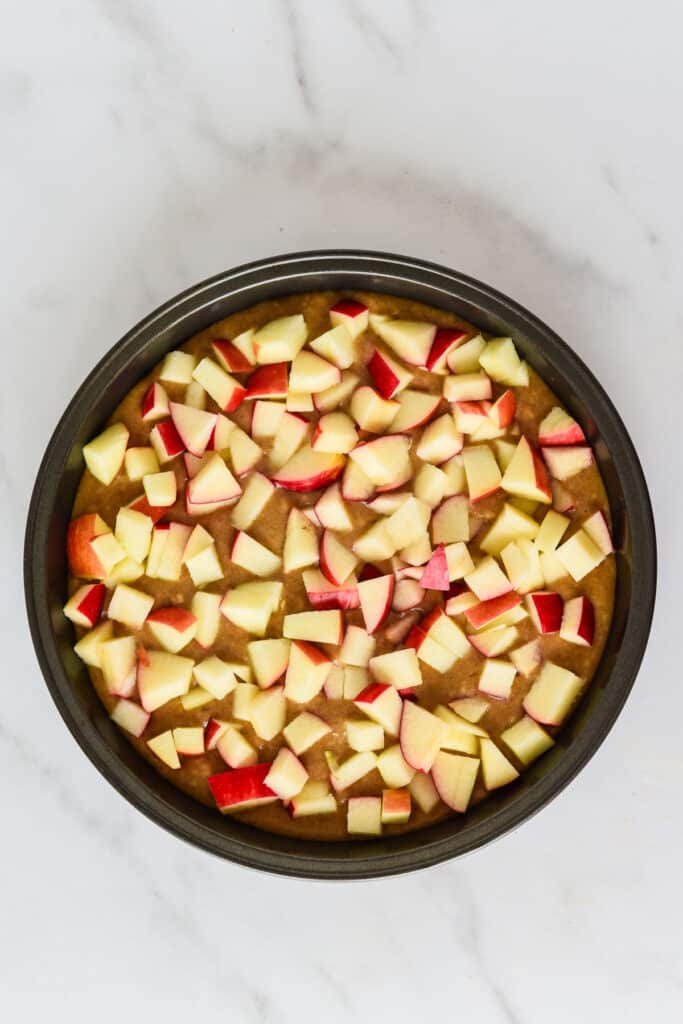 cake pan with batter and diced apples