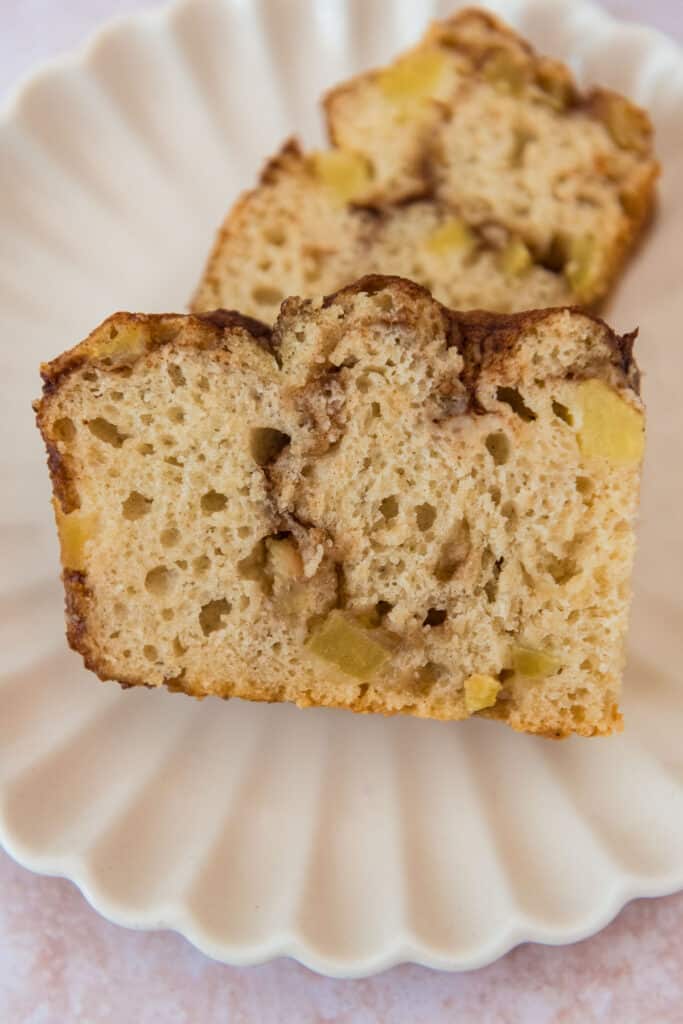 closeup of two slices of sourdough apple focaccia with cinnamon filling on white plate