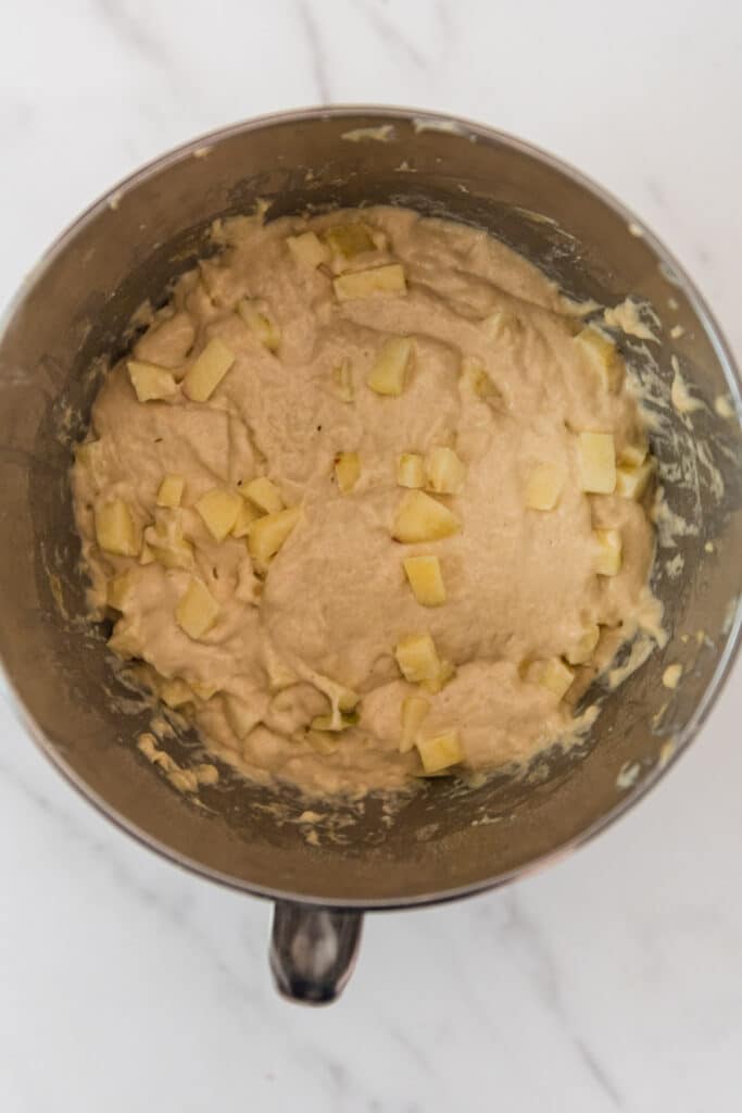 sourdough focaccia dough in metal mixing bowl with diced apple pieces