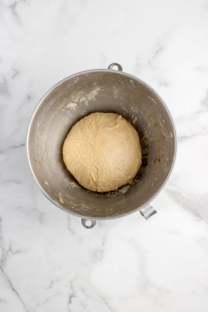 metal mixing bowl with dough for pumpkin sourdough cinnamon rolls before proofing